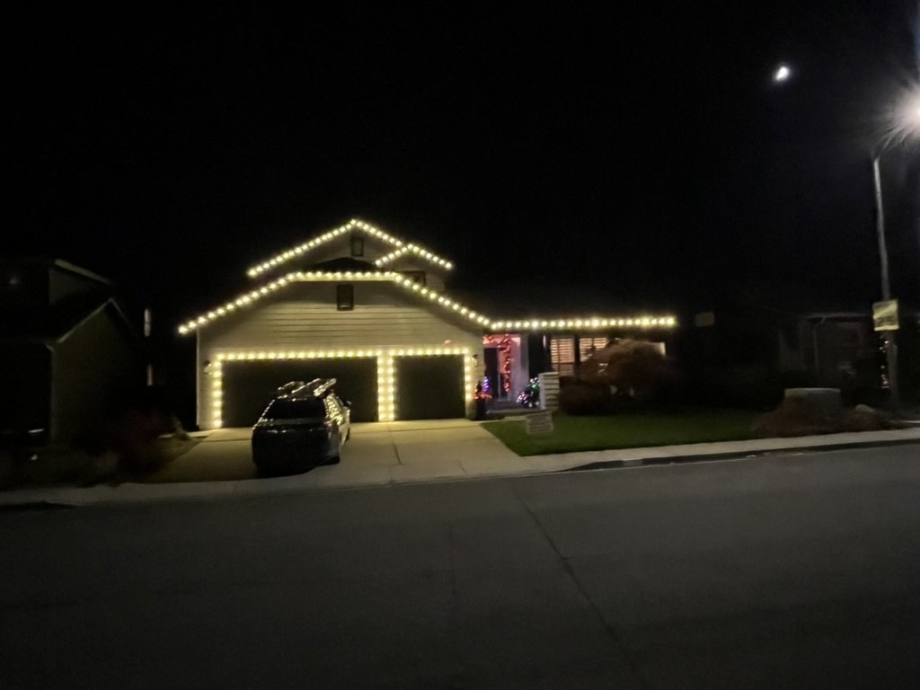 Home with layered gables outlined in warm white lights